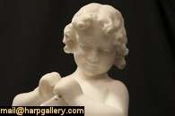 sculpture of a seated young girl peering down at her kitten was hand 